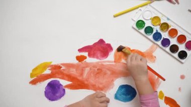 Suluboya boya ve fırçalarla resim çizen sevimli bir bebek. Odaklanmış akıllı çocuk evde yaratıcı sanat hobisi, çocuk gelişimi konsepti