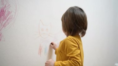 Sevimli sevimli küçük kız ressam tebeşirle boyama resmi çiziyor, beyaz duvara boya kalemi çiziyor, akıllı anaokulu öğrencisinin evde yaratıcı sanat hobilerini sevmesi, çocuk gelişimi konsepti.