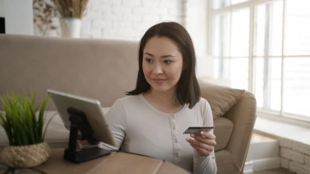 Blandad ras asiatisk kvinna shoppare spendera pengar via e-handel e-butiker, inköp på internet med enkel metod, betala hålla kreditkort med hjälp av surfplatta dator. Modern teknik, säker betalning, försäljning rabatt koncept — Stockvideo