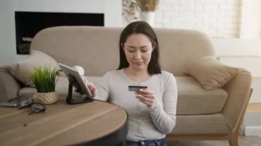 Karma ırk Asyalı kız müşterinin internet alışverişi yapması evde tablet üzerinden güvenli online ödeme yapmalarını sağlıyor. Milenyum müşterisi internet sitesinden sipariş veriyor..