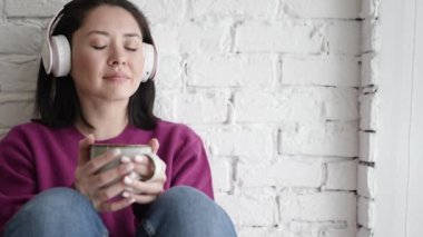 Kulaklıklı, Asyalı, rüya gibi genç bir kadın işe başlamadan önce evde otururken en sevdiği çayı içiyor ve sabah kahvesini içiyor. Mola, duraklat, hayal kurma kavramı