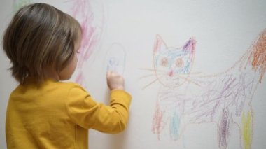 Sevimli sevimli küçük kız ressam tebeşirle boyama resmi çiziyor, beyaz duvara boya kalemi çiziyor, akıllı anaokulu öğrencisinin evde yaratıcı sanat hobilerini sevmesi, çocuk gelişimi konsepti.