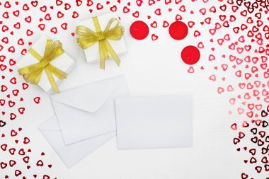 El yapımı kağıt hediye kutuları, zarflar ve mumların bileşimi. Kalpleri beyaz ahşap bir masaya yerleştirir. Doğum günü için içerik, Sevgililer Günü, Kadınlar Günü. Düz yat, üst görünüm, kapat, boşluğu kopyala