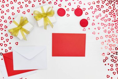 El yapımı kağıt hediye kutuları, zarflar ve mumların bileşimi. Kalpleri beyaz ahşap bir masaya yerleştirir. Doğum günü için içerik, Sevgililer Günü, Kadınlar Günü. Düz yat, üst görünüm, kapat, boşluğu kopyala