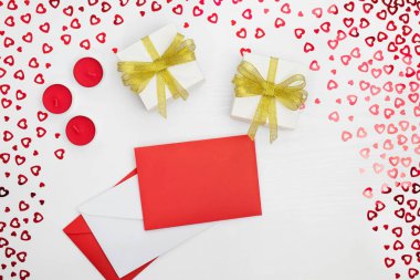 El yapımı kağıt hediye kutuları, zarflar ve mumların bileşimi. Kalpleri beyaz ahşap bir masaya yerleştirir. Doğum günü için içerik, Sevgililer Günü, Kadınlar Günü. Düz yat, üst görünüm, kapat, boşluğu kopyala