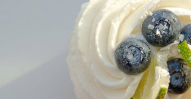 Krema şapkalı, yaban mersinli ve limonlu leziz kek.