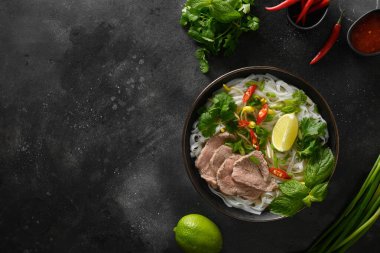 Siyah arka planda kasede sığır etli Pho Bo Çorbası. Vietnam mutfağı..