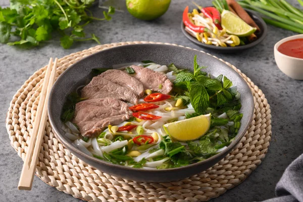 Pho Bo Sopa con carne de res en tazón gris sobre gris. Cocina vietnamita. —  Fotos de Stock