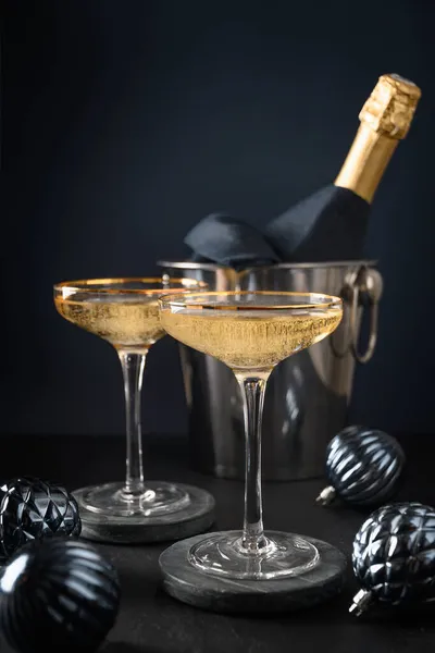 Γιορτινή σαμπάνια σε ποτήρια κρασιού και χριστουγεννιάτικα μπλε μπιχλιμπίδια σε σκούρο φόντο. 2022 Πρωτοχρονιάτικο πάρτι — Φωτογραφία Αρχείου
