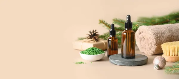 Christmas Spa Wellness-Konzept mit kosmetischem Aromaöl, Tannenzapfen auf beigem Hintergrund. — Stockfoto