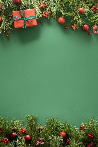 Cornice natalizia con regalo rosso, rami di pino e palline rosse. Biglietto di auguri natalizio. — Foto Stock