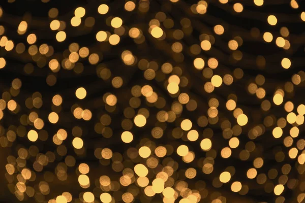 Blurred gold garland. City night light blur bokeh, defocused background. Christmas abstract. — Stock Photo, Image