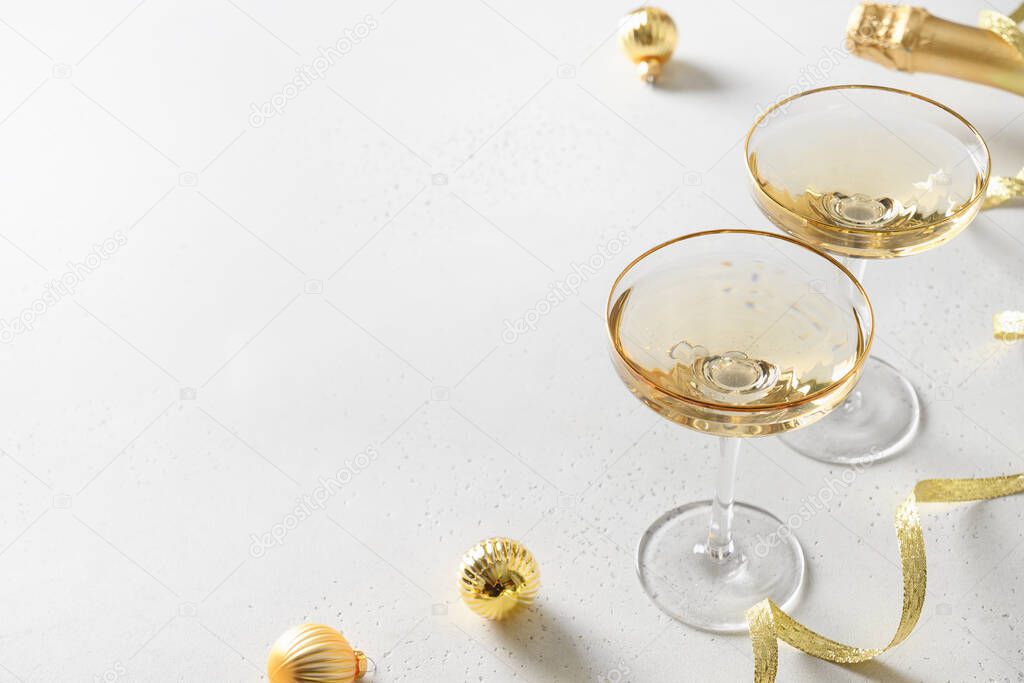 Festive New Year champagne and Christmas gold baubles on white background.