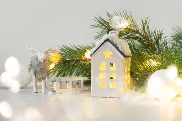 Vánoční pohádka s kouzelným zasněženým domem, jelenem a saněmi. — Stock fotografie