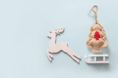 Beyaz ahşap ren geyikleri, Noel ağacı ve mavi arka planda kıvrımlı Noel kompozisyonu. Pankart. Kopyalama alanı olan tebrik kartı.