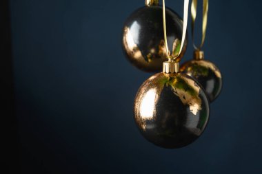 Noel siyah takıları koyu mavi arka planda altın metalik potasyum yaprak süslemiştir. Modern lüks metalik eğilimli tebrik kartı.