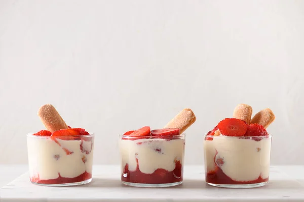 Három adag réteges desszert üvegedényekben, süti savoyardival, mascarpone sajttal és tejszínhabbal.. — Stock Fotó