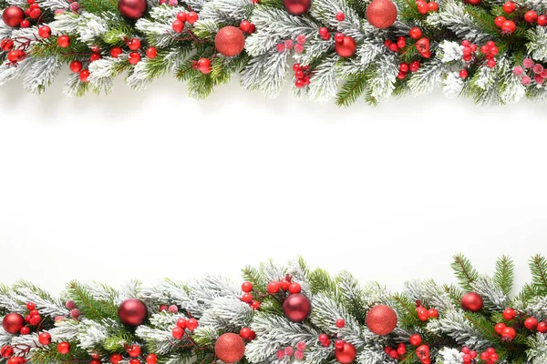 Banner de Navidad con adornos rojos en ramas perennes nevadas. — Foto de Stock