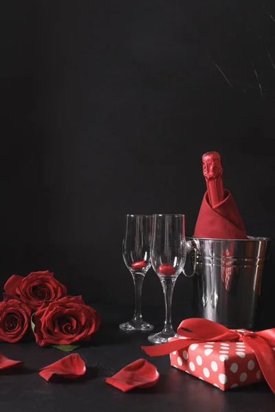 浪漫的约会与闪耀的酒，礼物，一束红玫瑰在黑色。情人节的庆祝活动. — 图库照片