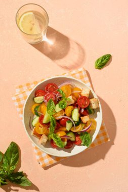 Tuscan Panzanella with tomatoes and bread on sunny table. Top view. Traditional Italian cuisine. Mediterranean healthy food.