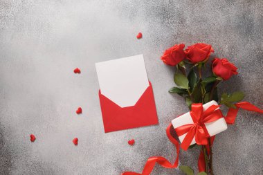 Valentines day card with romantic gift, red roses and heart shaped cookies.