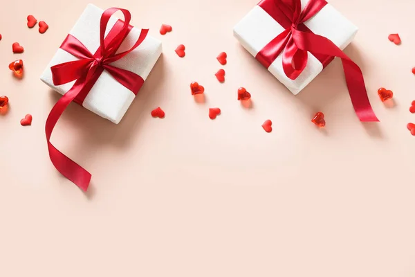 Dia dos Namorados presente para dois com fita vermelha e confete em forma de coração. — Fotografia de Stock