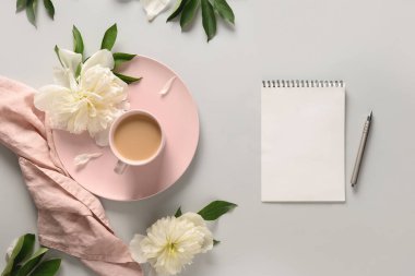 Kahve fincanı ve gri ofis masasında beyaz şakayık planlamak için boş..