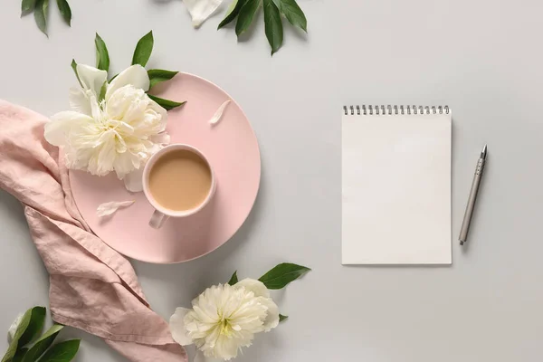 Kahve fincanı ve gri ofis masasında beyaz şakayık planlamak için boş..