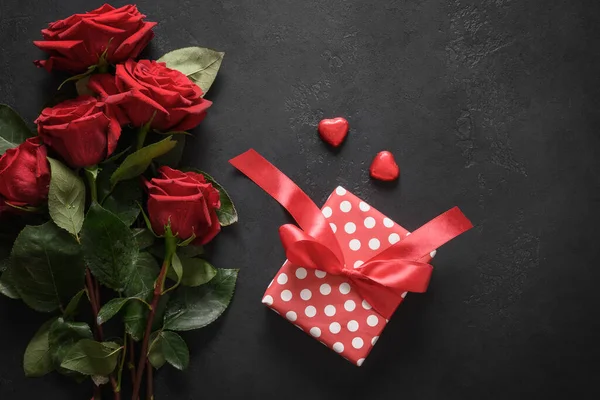 Buquê de rosas vermelhas e presente. Dia dos Namorados cartão de saudação. — Fotografia de Stock