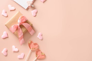 Sevgililer günü tebrik kartı, hediye, aşk mektubu, iki tatlı lolipop ve pembe arka planda pembe kalpler. Yukarıdan bak. Mesaj için yer var. Düz yatıyordu.