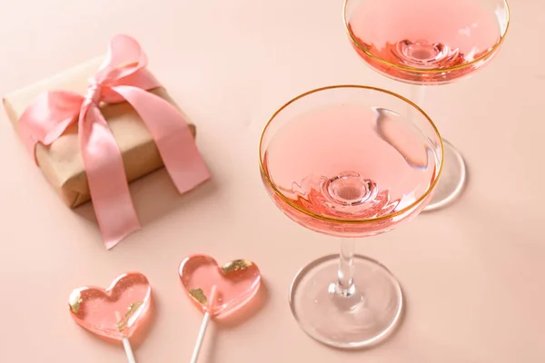 浪漫的概念与节日香槟酒 礼物和两个粉色棒棒糖粉红背景 情人节单色贺卡 靠近点 — 图库照片
