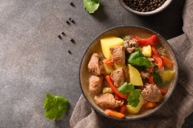 Kahverengi arka planda sebzeli biftek güveci..