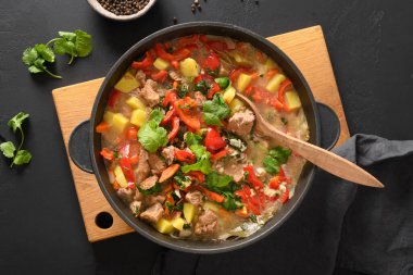 Sebzeli biftek yahnisi, patates, kahverengi arka planda biber..