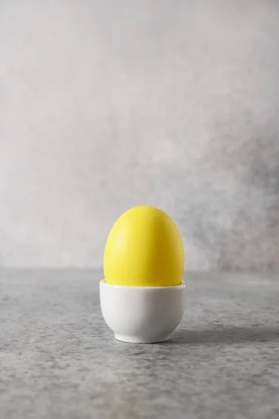 Påskgult ägg i monter för semester frukost i minimal stil. — Stockfoto