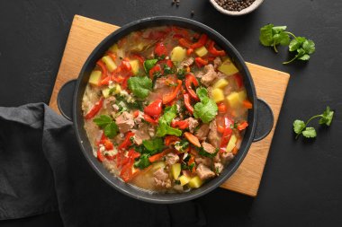 Kış yemeği için ev yapımı sığır güveci. Sebze, patates, biber ve siyah arka planda havuç. Avrupa mutfağı. Üst görünüm.