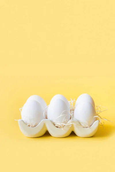 Huevos de pollo blancos orgánicos en caja decorativa de porcelana en amarillo . — Foto de Stock