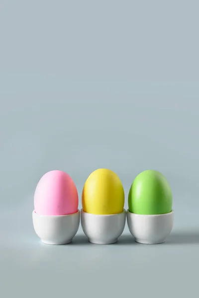 Pasen kleurrijke kippeneieren in decoratieve witte standaards. — Stockfoto