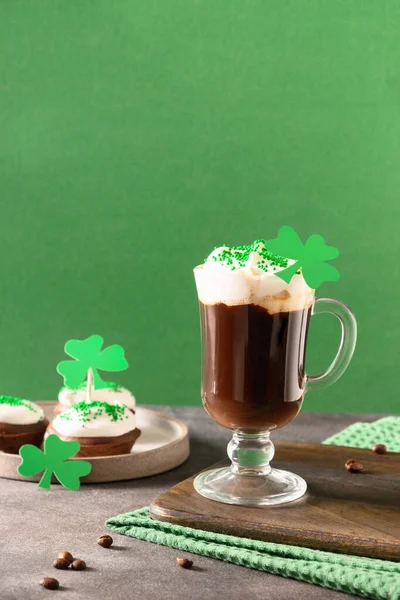 Irish coffee in green cup and special cupcakes for St Patrick s Day. — Stock Photo, Image