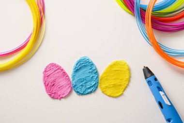 Paskalya tatili için popüler plastikten yaratıcı renkli yumurtalar. Gökkuşağı plastik lifleri ve beyaz arka planda 3 boyutlu kalemler var. Çocuk için yeni bir oyuncak. Üst görünüm