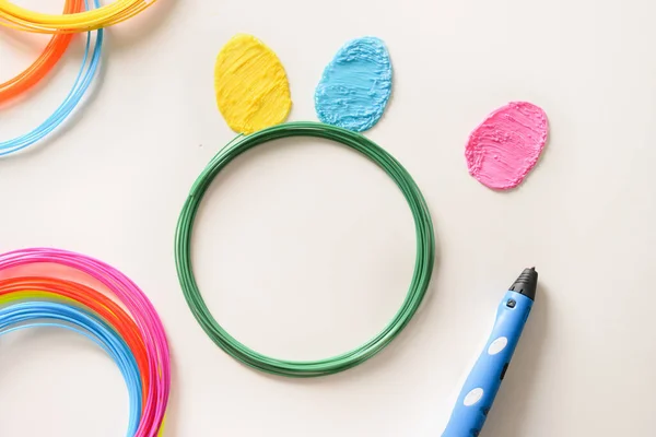 Uova colorate creative di plastica per le vacanze di Pasqua. Filamenti di plastica arcobaleno con per la posa di penne 3D. — Foto Stock