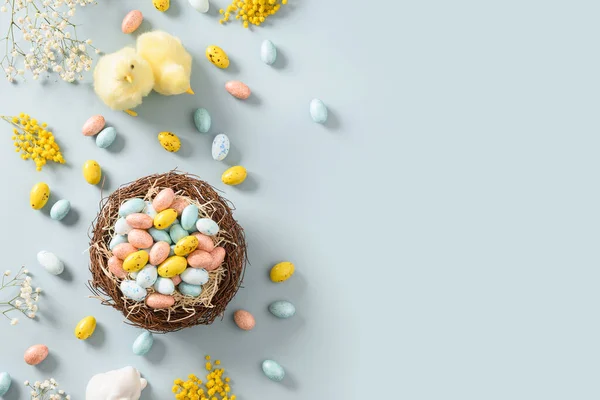 Burla de Pascua con huevos de chocolate pastel sobre fondo azul. — Foto de Stock