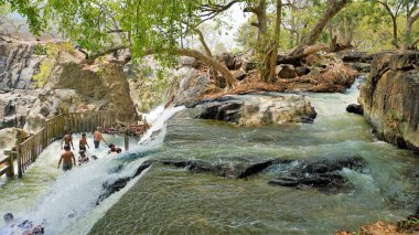 Hogenakkal, Tamilnadu, Hindistan-19 Mart 2022: Hogenakkal şelalelerinde yıkanan turistler. Hogenakkal Şelalesi, Hindistan 'ın Tamilnadu kentinin başlıca turistik merkezlerinden biridir. Bangalore 'a 180 km, Dharmapuri' ye 46 km uzaklıktadır..