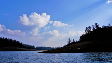 Pykara Gölü, Ooty, Tamilnadu 'nun güzel manzarası. Gökyüzünün muhteşem manzarası, su ve tekne yolculuğundan görülebilen yeşil çalılar. Güney Hindistan 'daki en iyi balayı yeri..