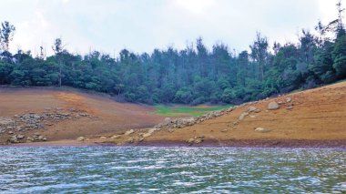 Pykara Gölü, Ooty, Tamilnadu 'nun güzel manzarası. Gökyüzünün muhteşem manzarası, su ve tekne yolculuğundan görülebilen yeşil çalılar. Güney Hindistan 'daki en iyi balayı yeri..
