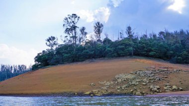 Pykara Gölü, Ooty, Tamilnadu 'nun güzel manzarası. Gökyüzünün muhteşem manzarası, su ve tekne yolculuğundan görülebilen yeşil çalılar. Güney Hindistan 'daki en iyi balayı yeri..