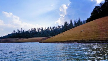 Pykara Gölü, Ooty, Tamilnadu 'nun güzel manzarası. Gökyüzünün muhteşem manzarası, su ve tekne yolculuğundan görülebilen yeşil çalılar. Güney Hindistan 'daki en iyi balayı yeri..