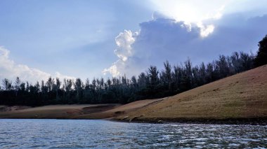 Pykara Gölü, Ooty, Tamilnadu 'nun güzel manzarası. Gökyüzünün muhteşem manzarası, su ve tekne yolculuğundan görülebilen yeşil çalılar. Güney Hindistan 'daki en iyi balayı yeri..
