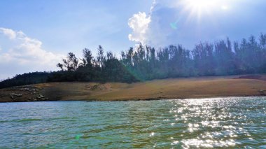 Pykara Gölü, Ooty, Tamilnadu 'nun güzel manzarası. Gökyüzünün muhteşem manzarası, su ve tekne yolculuğundan görülebilen yeşil çalılar. Güney Hindistan 'daki en iyi balayı yeri..