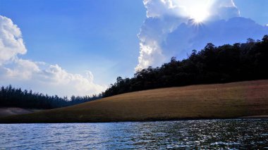 Pykara Gölü, Ooty, Tamilnadu 'nun güzel manzarası. Gökyüzünün muhteşem manzarası, su ve tekne yolculuğundan görülebilen yeşil çalılar. Güney Hindistan 'daki en iyi balayı yeri..