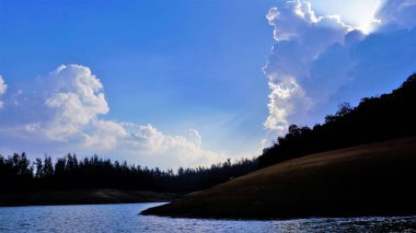 Pykara Gölü, Ooty, Tamilnadu 'nun güzel manzarası. Gökyüzünün muhteşem manzarası, su ve tekne yolculuğundan görülebilen yeşil çalılar. Güney Hindistan 'daki en iyi balayı yeri..